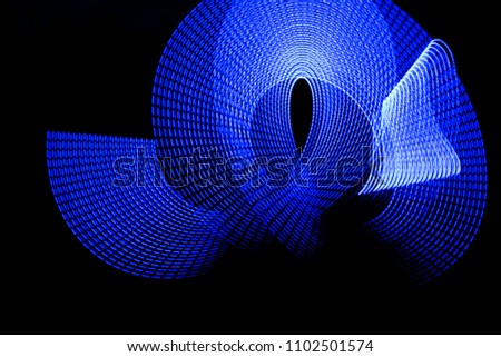 Blue electric light painting, long exposure photography, ripples and waves pattern against a black background