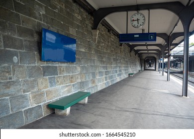 Blue empty station sign , clock and green seat at platform in train station for background , copy space , Zurich , Switzerland