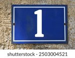 A blue enamel house number plaque, showing the white coloured number 1 (number one)