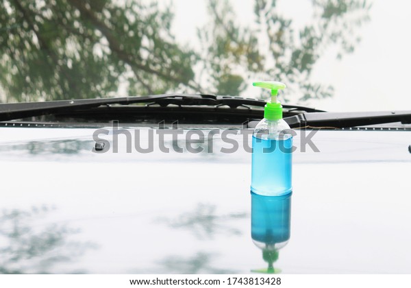 Blue ethyl alcohol hand gel pump bottle place on\
the car, idea, and concept of coronavirus, covid19 with blur and\
soft focus.
