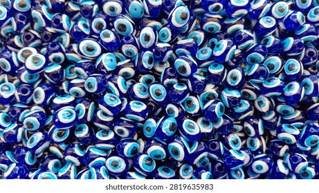 Blue Evil Eye Beads Background Pattern. Traditional Turkish Nazar Amulet Texture. evil eye, nazar, nazar bead, turkey, turkish, blue, background, pattern, texture, amulet, protection, symbol, culture, traditional, decorative, ornament, glass, bead, lucky charm, spirituality, belief, talisman, detail, close up, macro, repetition, design, abstract, full frame, vibrant, glossy, handmade, souvenir, market, craft, ethnic, folklore, middle east, mediterranean, pattern background, texture background, blue color, cultural symbol, no people, tourism, decorative art, wall decor, repeating pattern, artistic, spiritual