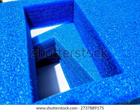 blue expanded polyethylene (EPE) foam packaging trays stacked on a tiled floor, designed for protective cushioning and industrial shipping solutions.
