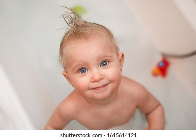 Blue eye baby girl looking up with a cute face in a bath
