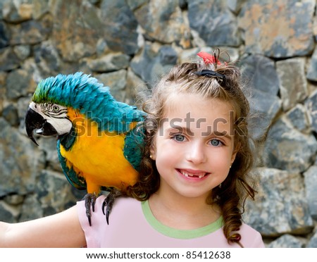 blue eyes child girl with yellow parrot in her shoulder