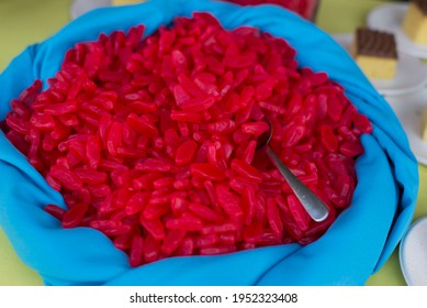 A Blue Fabric Bowl Of Red Swedish Fish Gummy Candy