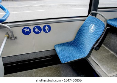 Blue fabric seat in the bus for elderly, people with disabilities and passengers with children. Space for guide dog in bus. Special seats in public transport for certain categories of passengers.