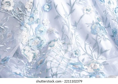 blue festive fabric decorated with embroidery and sequins for wedding dress. glossy textile for sewing prom dress