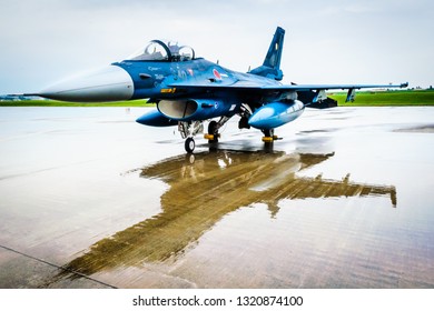 Blue Fighter Jet From Japan Air Self Defense Force On Display And Reflected On Flight Line After Heavy Rain 