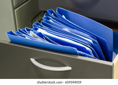 Blue File Folder Documents In A File Cabinet . Retention Of Contracts - Concept