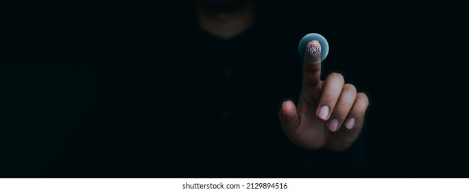 Blue fingerprint scan icon on virtual screen while finger scanning for security access with biometrics identification on dark. Cyber security, privacy data protection technology for business.