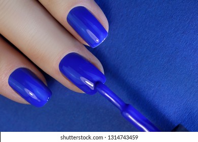 Blue Fingers Nail Point Isolated Blue Background With Nail Polish. Painting Nails.