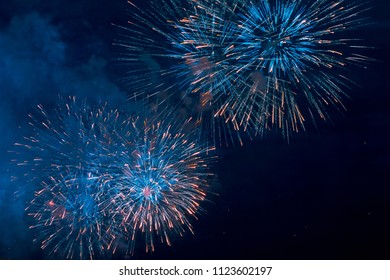 Blue fireworks display on dark sky background. Christmas. Fireworks at New Year.. Independence Day. Fantastic show. The holiday of graduates. Holiday decorating. Magic night. Wedding fireworks. 