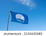 Blue flag,symbol of clean nice beach flying on background of sky.Copy space.