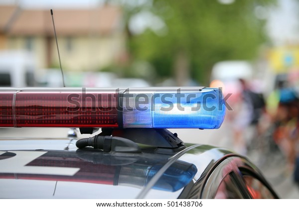 blue flashing lights of the police car at a sports\
event in the city