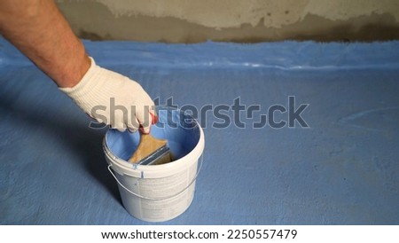 Blue floor waterproofing in the bathroom. The bathroom floor was painted blue. The floor is covered with blue waterproofing. Waterproofing the joint of the wall with the floor.