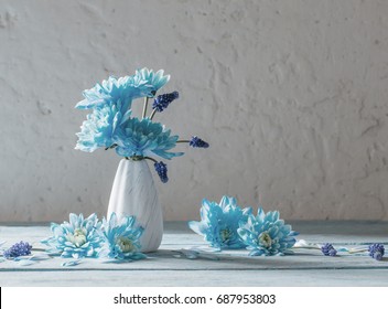 Blue Flowers In Vase On White Grunge Background