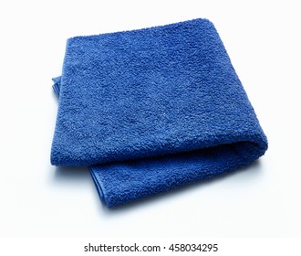 Blue folded bath towel isolated on white background with copy space