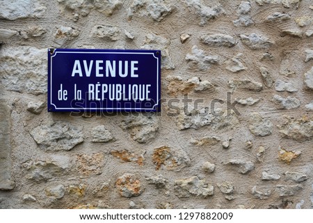 Blue french street sign in french with the writing in english 