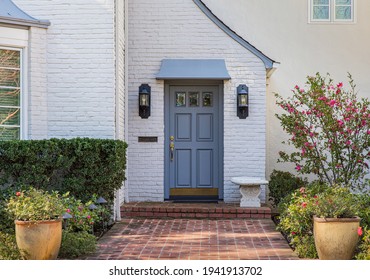 Blue Front Door Of Traditional Style Home With Brick Entry And White Brick Exterior.