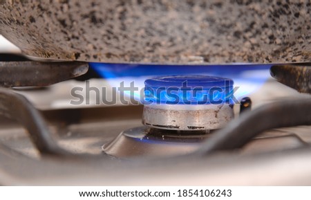 Blue gas flame on a dirty gas stove