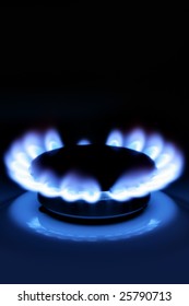 Blue gas flame on hob close up in the dark - Shutterstock ID 25790713
