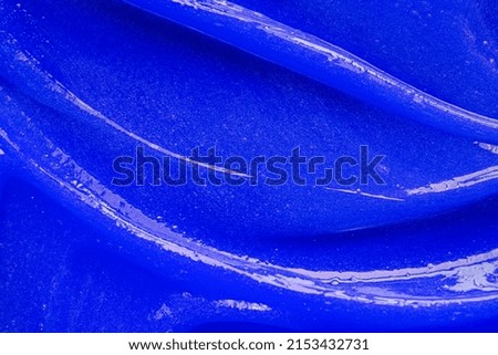 Blue gel texture. Cosmetic clear liquid cream smudge. Skin care product sample closeup. Toothpaste or wax background