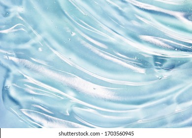 Blue gel texture. Hand sanitizer, alcohol gel background. Cosmetic clear liquid cream smudge. Transparent skin care product sample closeup