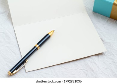 Blue gift box and ballpoint pen with blank card and golden ribbon - Shutterstock ID 1792921036