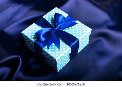 Blue Gift Box With A Bow On A Blue Background. Holiday Greeting Card.