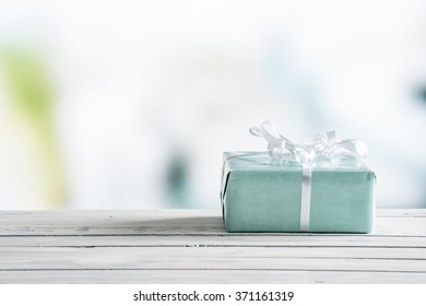 Blue Gift Box On A Wooden Table In Bright Light