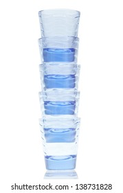 Blue Glass Stacked Shot Glasses On A White Background