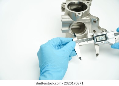 Blue gloved hand of engineer measuring metal parts with digital vernier caliper in workshop
,concept of using CMM measuring tools - Powered by Shutterstock