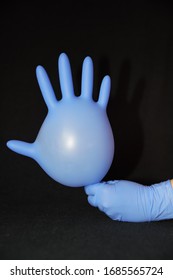 
Blue Gloved Hand, Holding Another Surgical Glove Inflated With Air