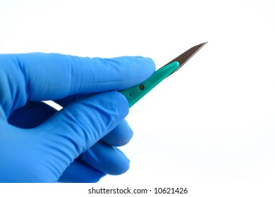 blue gloved hand holding scalpel on white background