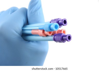 blue gloved hand holding six colored surgical introducers
