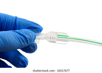 blue gloved hand putting a cap on surgical tubing