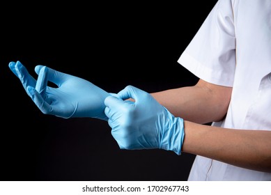 Blue gloves on the hands and black background