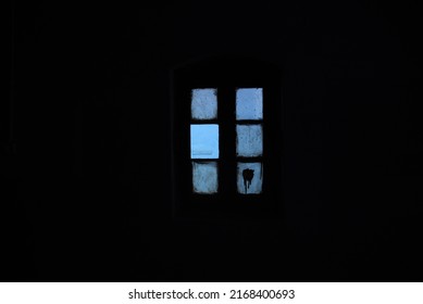 Blue glowing window against a black background, inside Dagshai Jail
