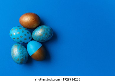 Blue and golden modern easter eggs on a white background. Top view. Easter concept. Isolated.