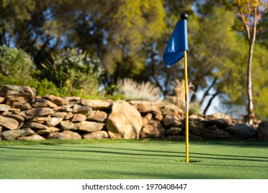Blue golf flag on a miniature golf putting green