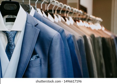 Blue and gray men suit jackets on hanger in a shop - Powered by Shutterstock