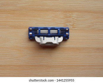 Blue And Gray Shaving Razor Blade Cartridge Kept On Wooden Table