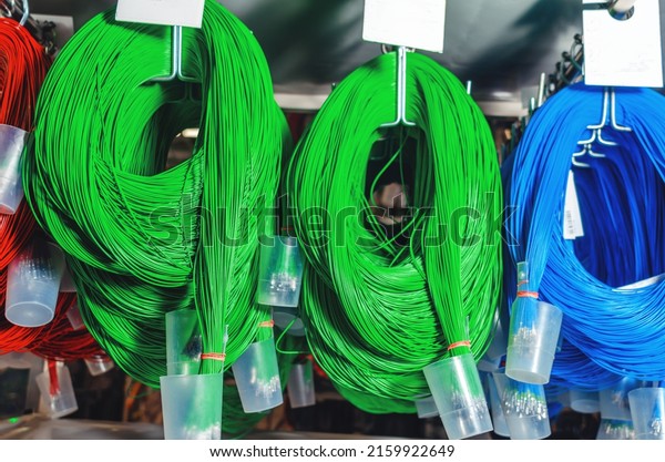 Blue and green bright\
wires. Skeins of colored cables for car production. Industrial\
details