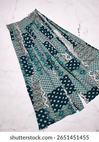 Blue green geometric print patchwork palazzo pants flat lay at gray marble background., Boho style wide leg cotton rayon yoga women's trousers. Clothes, apparel, fashion, vacation collection, shopping