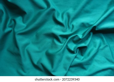 Blue green polyester fabric in soft folds