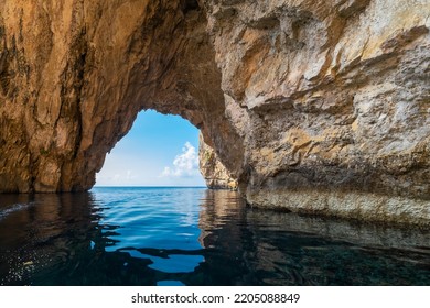 The Blue Grotto is a complex of sea caves along the Southeastern part of Malta, and on sunny days, the reflection of sunlight on the white sandy seafloor lights up the caves in bright blue hues - Shutterstock ID 2205088849