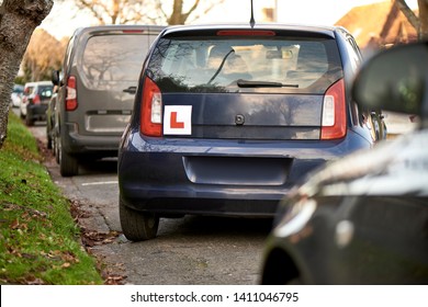 Blue Hatchback Car With A Learner Driver Sign At The Rear, Parking At The Side Of The Road, Parking Training, Parallel Parking