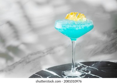 Blue Hawaiian Cocktail In Glass Summer Drink Concept. Blue Cocktail With Pineapple On Marble Table.