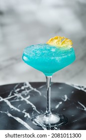 Blue Hawaiian Cocktail In Glass Summer Drink Concept. Blue Cocktail With Pineapple On Marble Table.