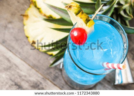Blue Hawaiian cocktail on wooden table. Copyspace